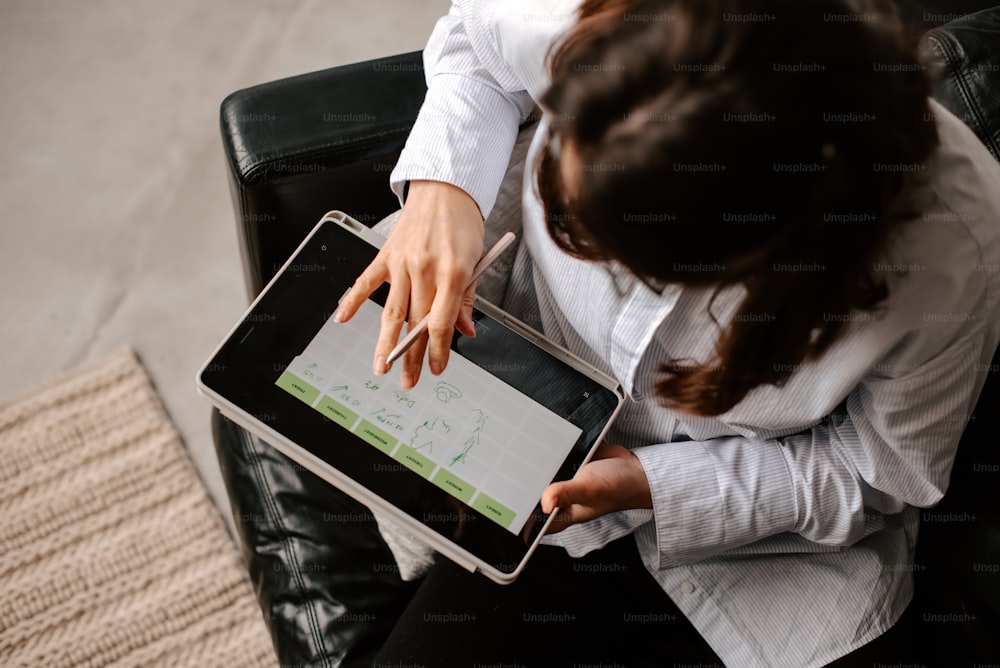 a woman sitting in a chair holding a tablet