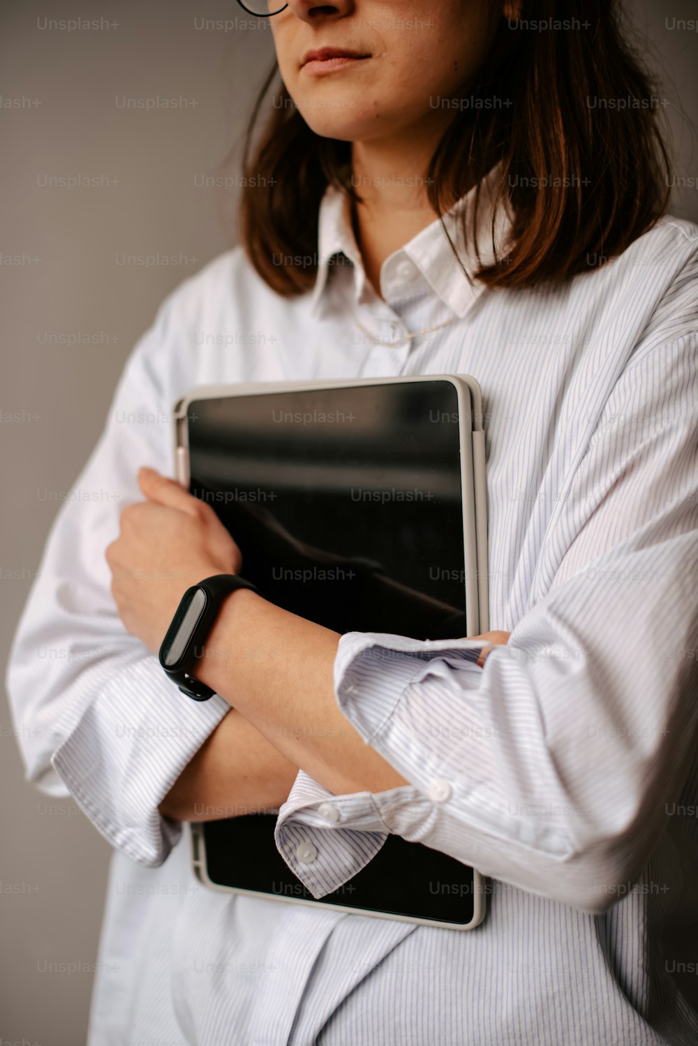 Eine Frau mit Brille hält einen Laptop in der Hand