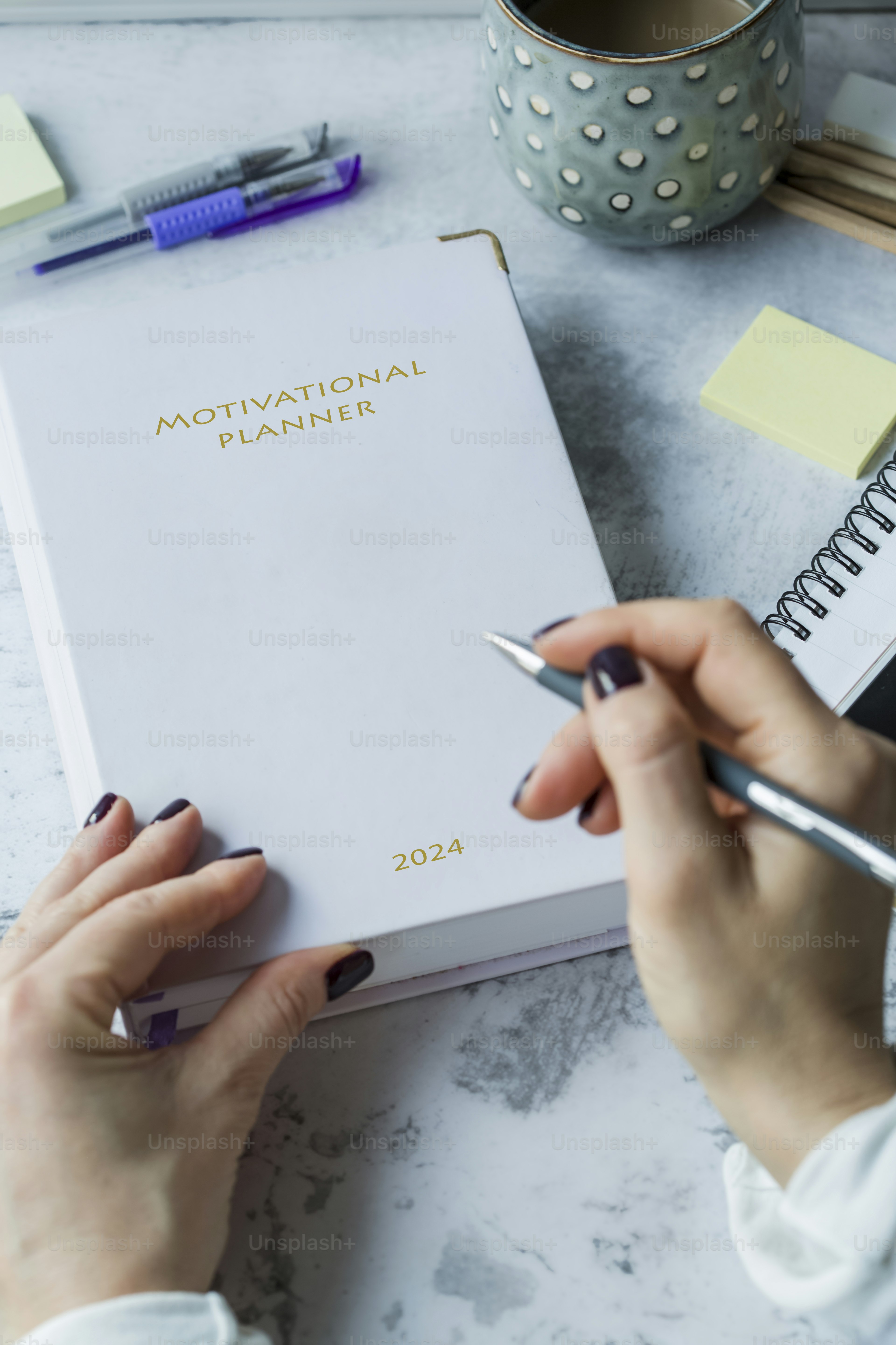 eine Frau, die einen Stift hält und auf ein Buch schreibt