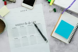 a desk with a notepad, pen and a cup of coffee