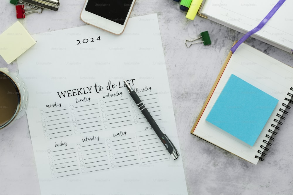 a desk with a notepad, pen and a cup of coffee