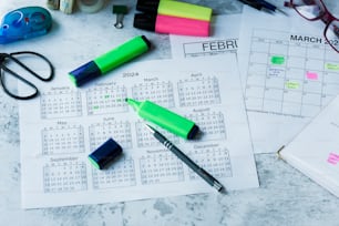 カレンダー、ペン、その他の事務用品を備えた机