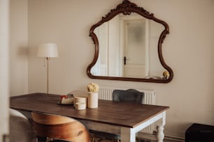 a wooden table sitting under a large mirror