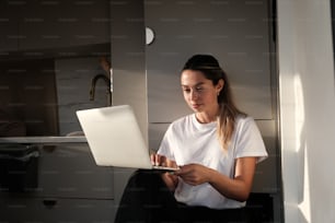 a woman sitting on the floor using a laptop computer