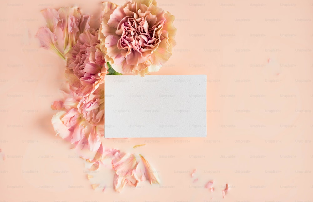 a white card with pink flowers on a pink background