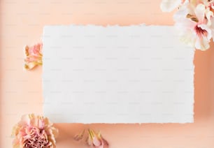 un pezzo di carta con fiori su sfondo rosa