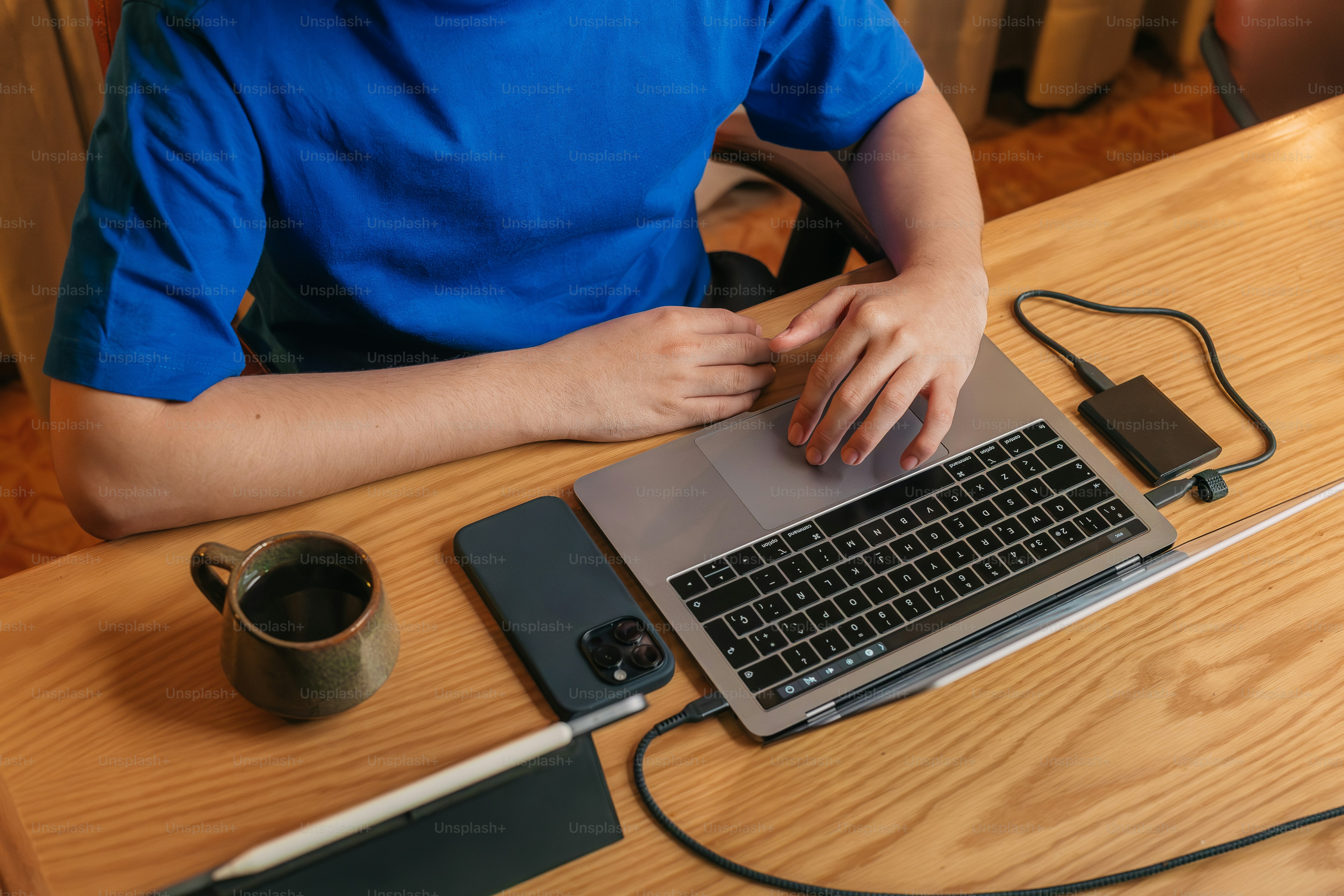 a person sitting at a table with a laptop