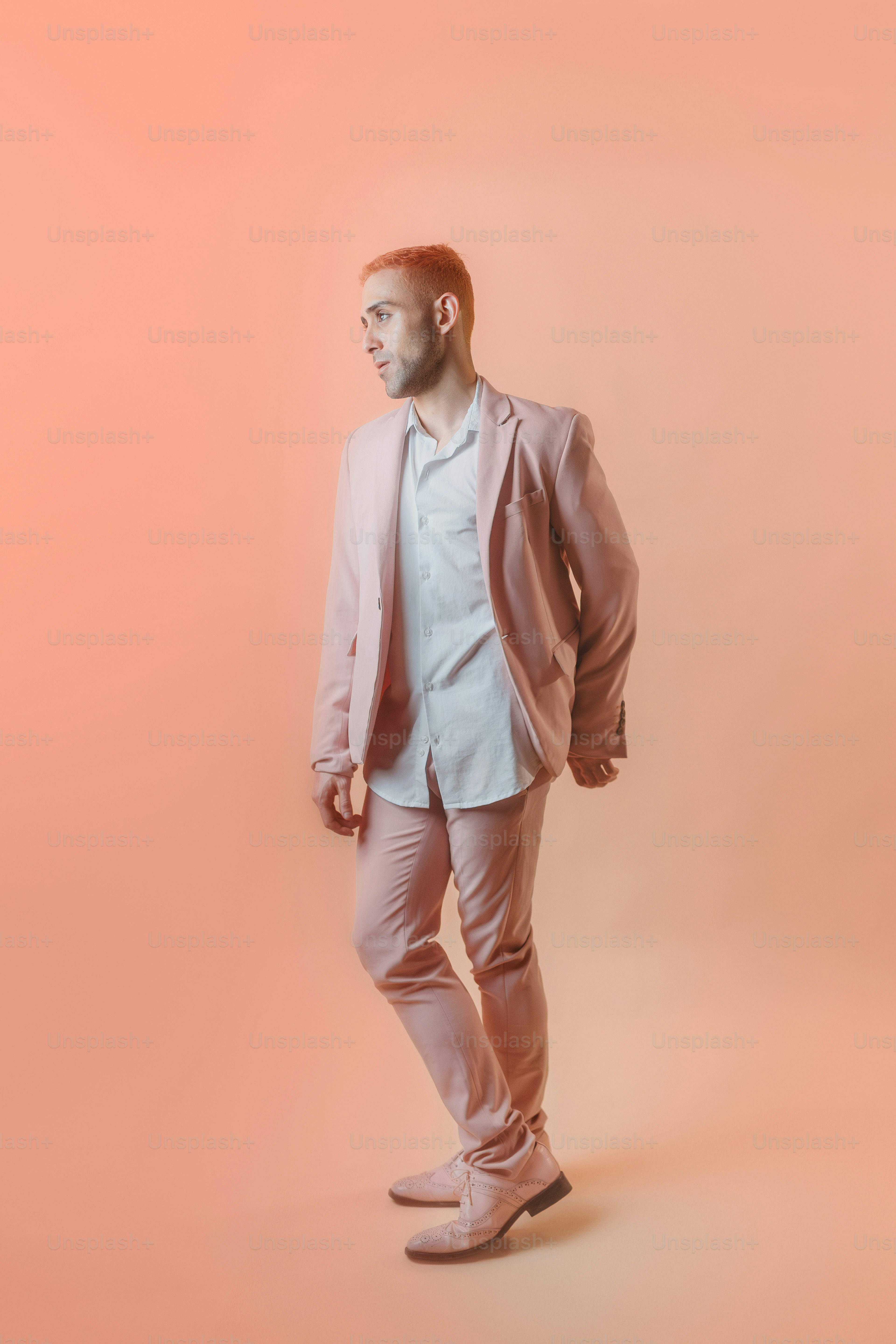 un homme vêtu d’une chemise blanche et d’un pantalon rose