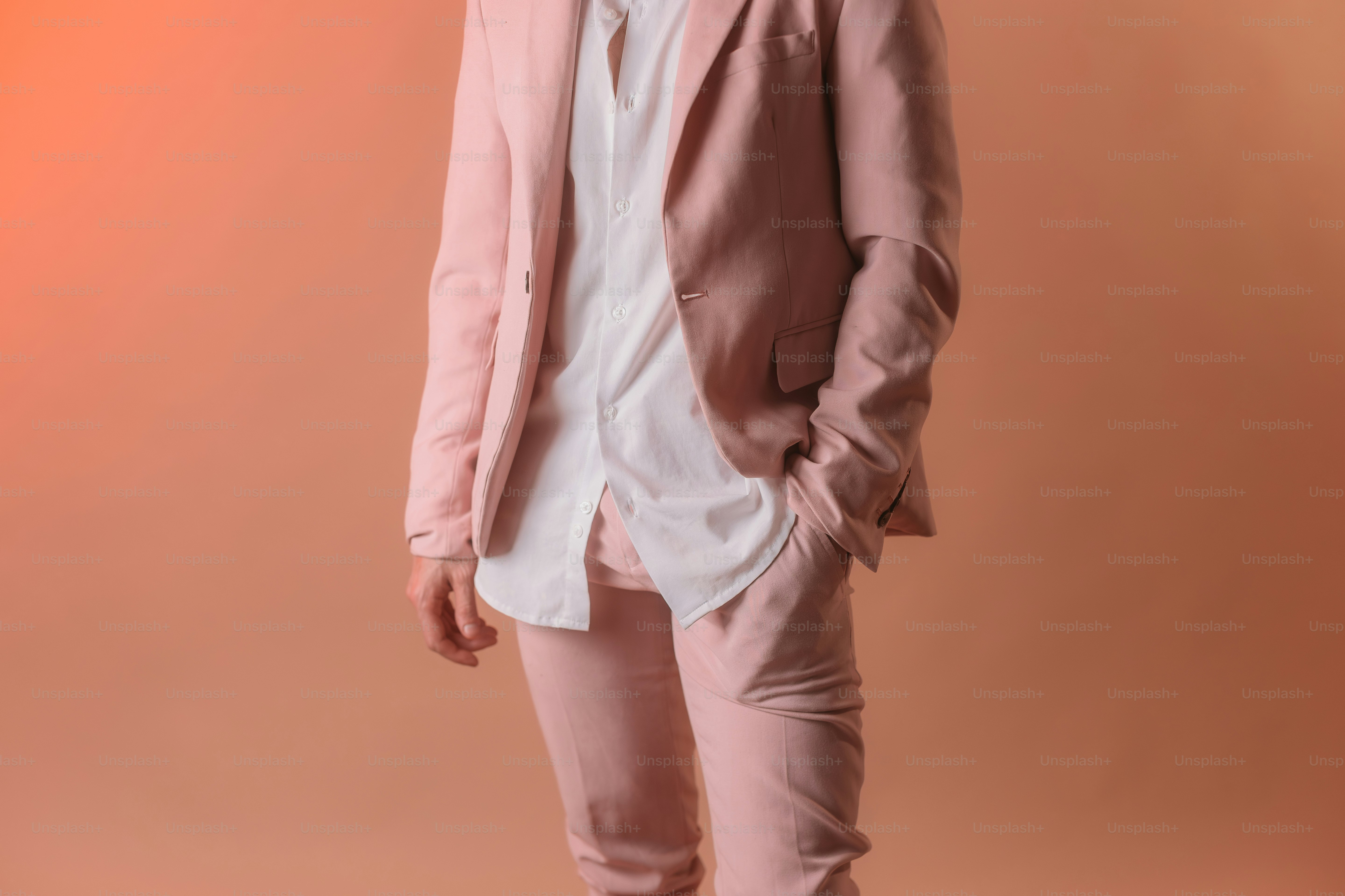 un homme en costume rose et chemise blanche