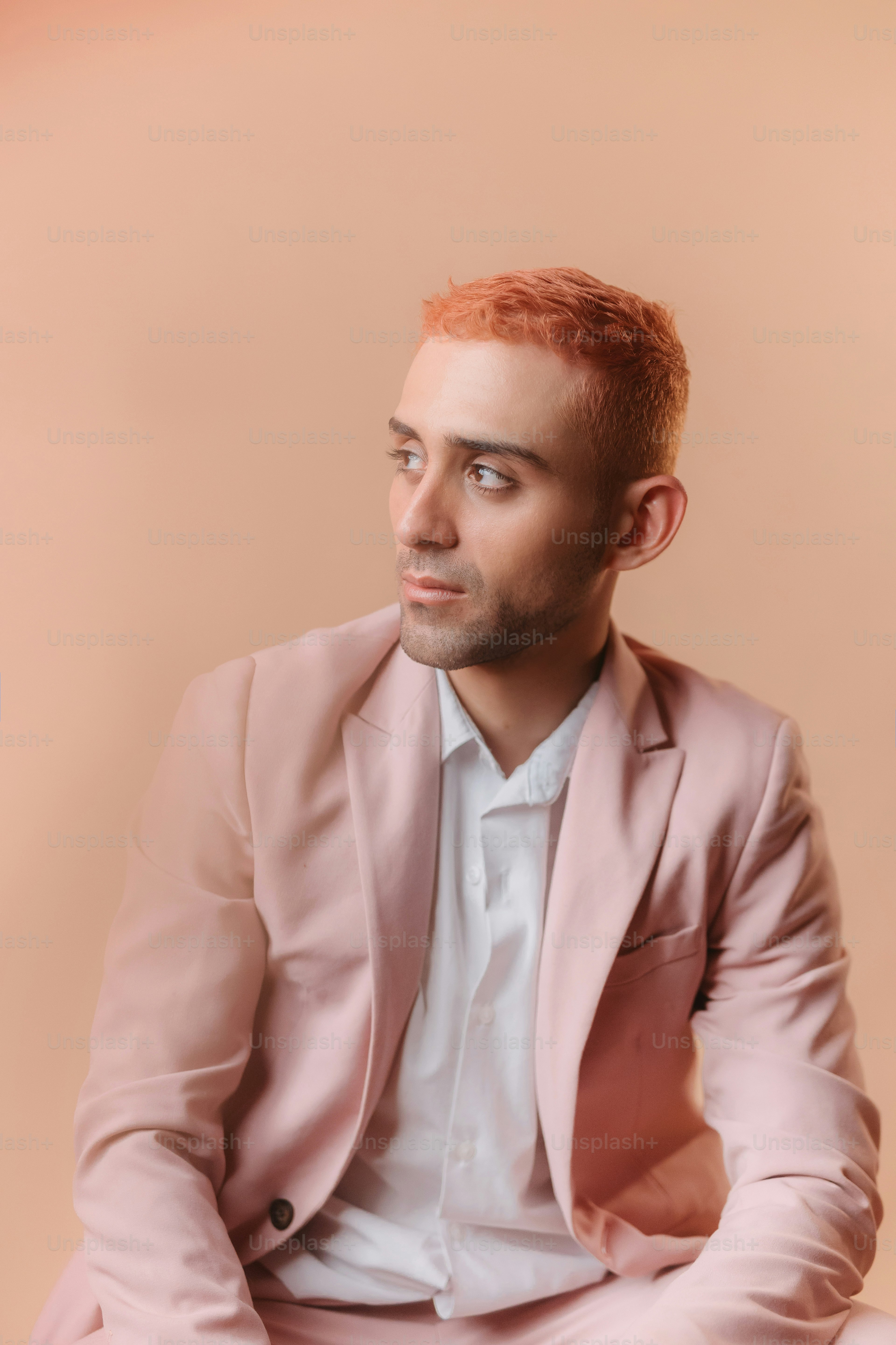 un homme en costume rose assis