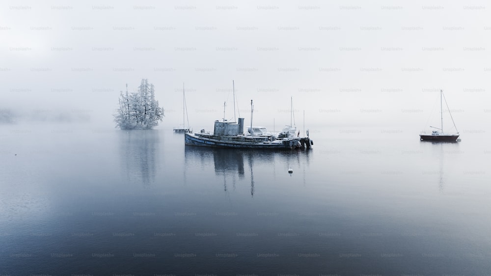 a couple of boats floating on top of a lake