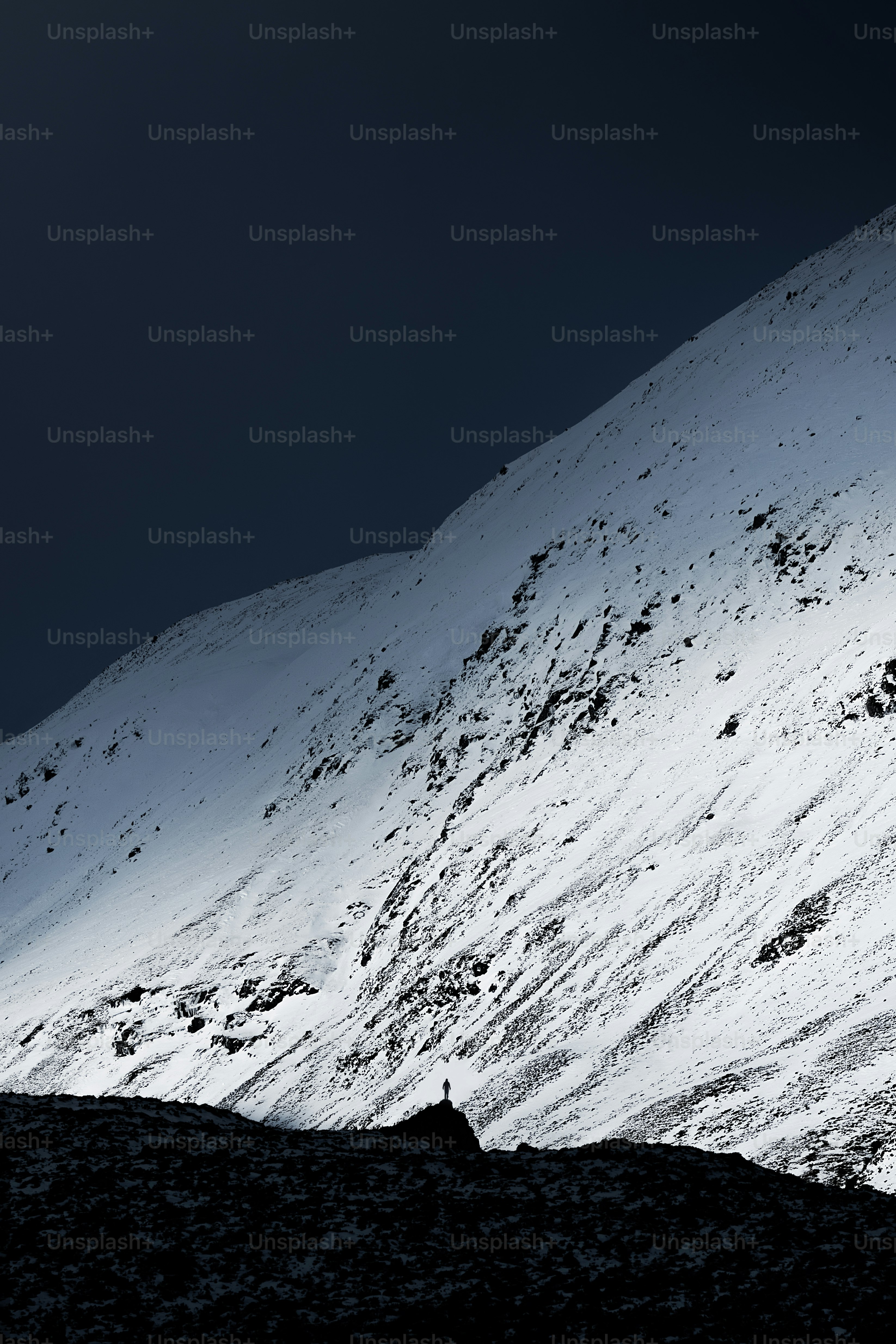 a person walking up the side of a snow covered mountain