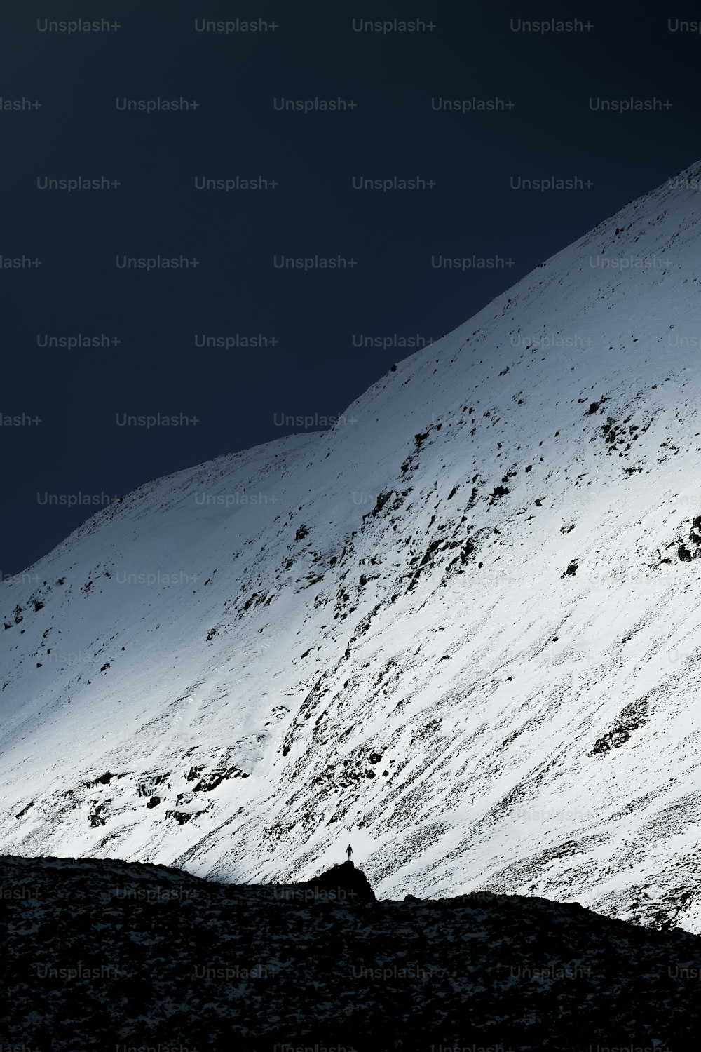 a person walking up the side of a snow covered mountain