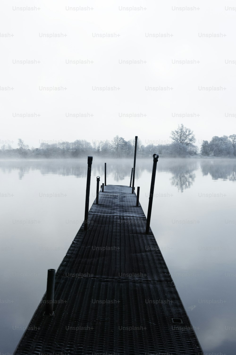 a dock on a lake in the middle of a foggy day