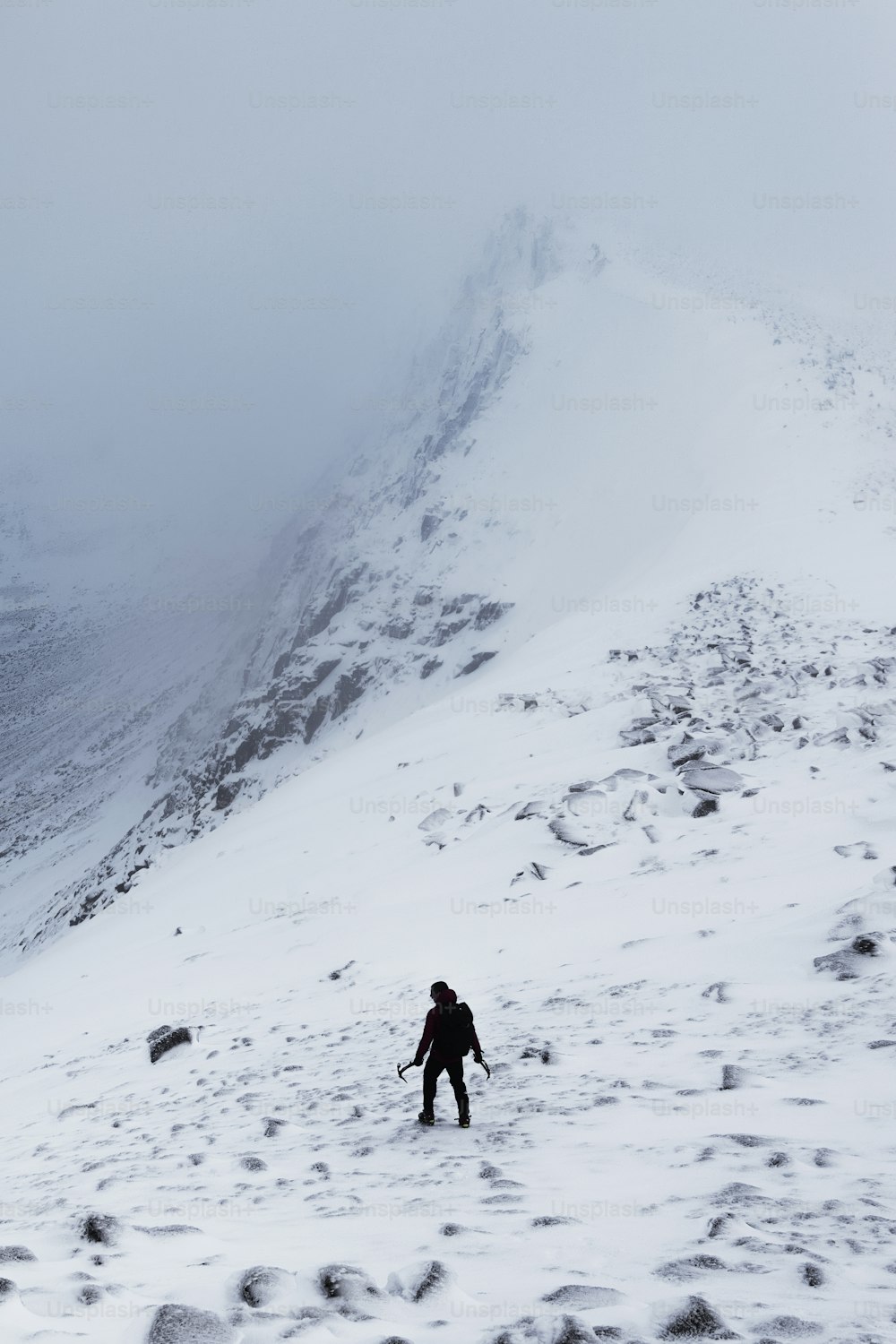 a person walking up a snow covered mountain