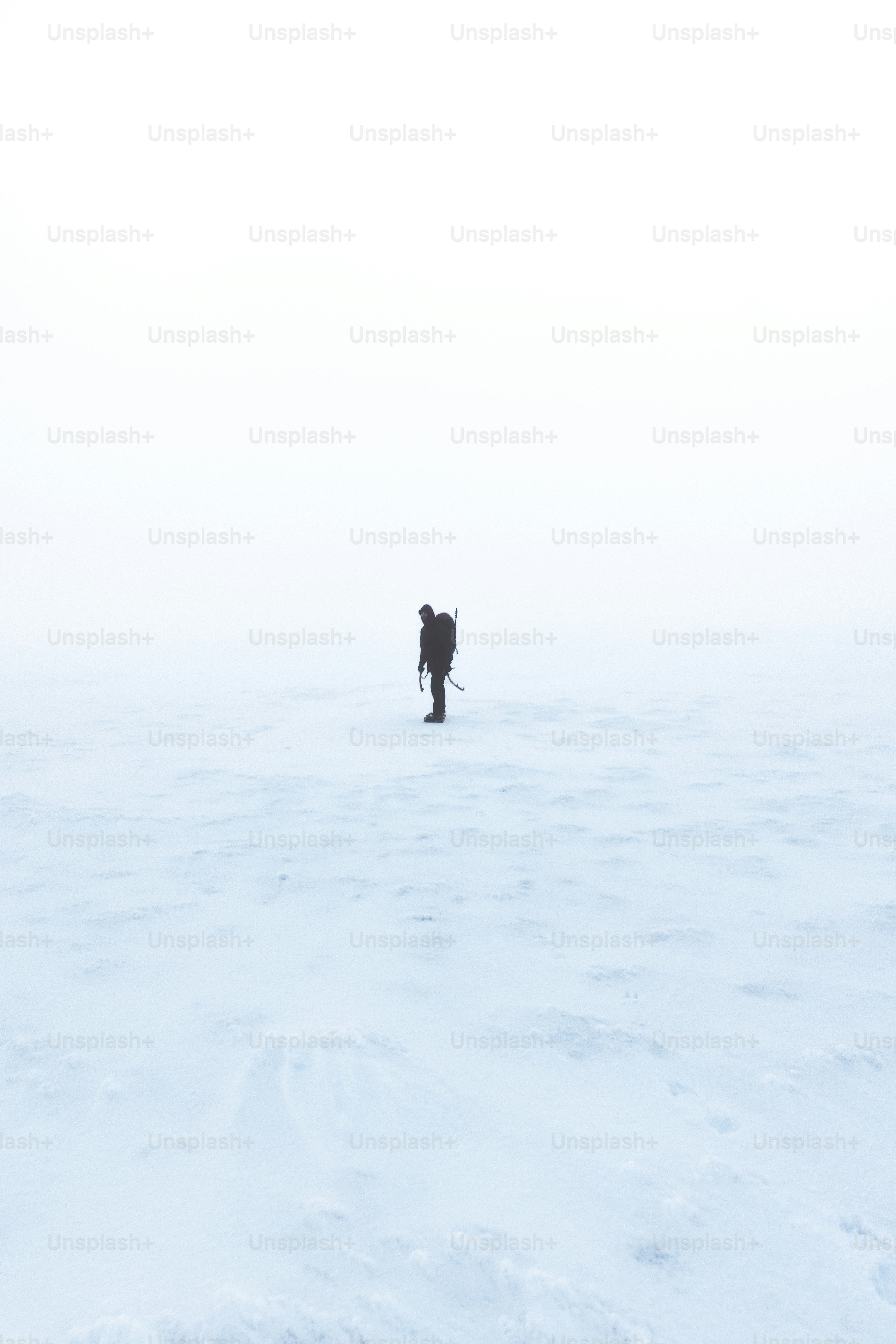 une personne marchant à travers un champ enneigé