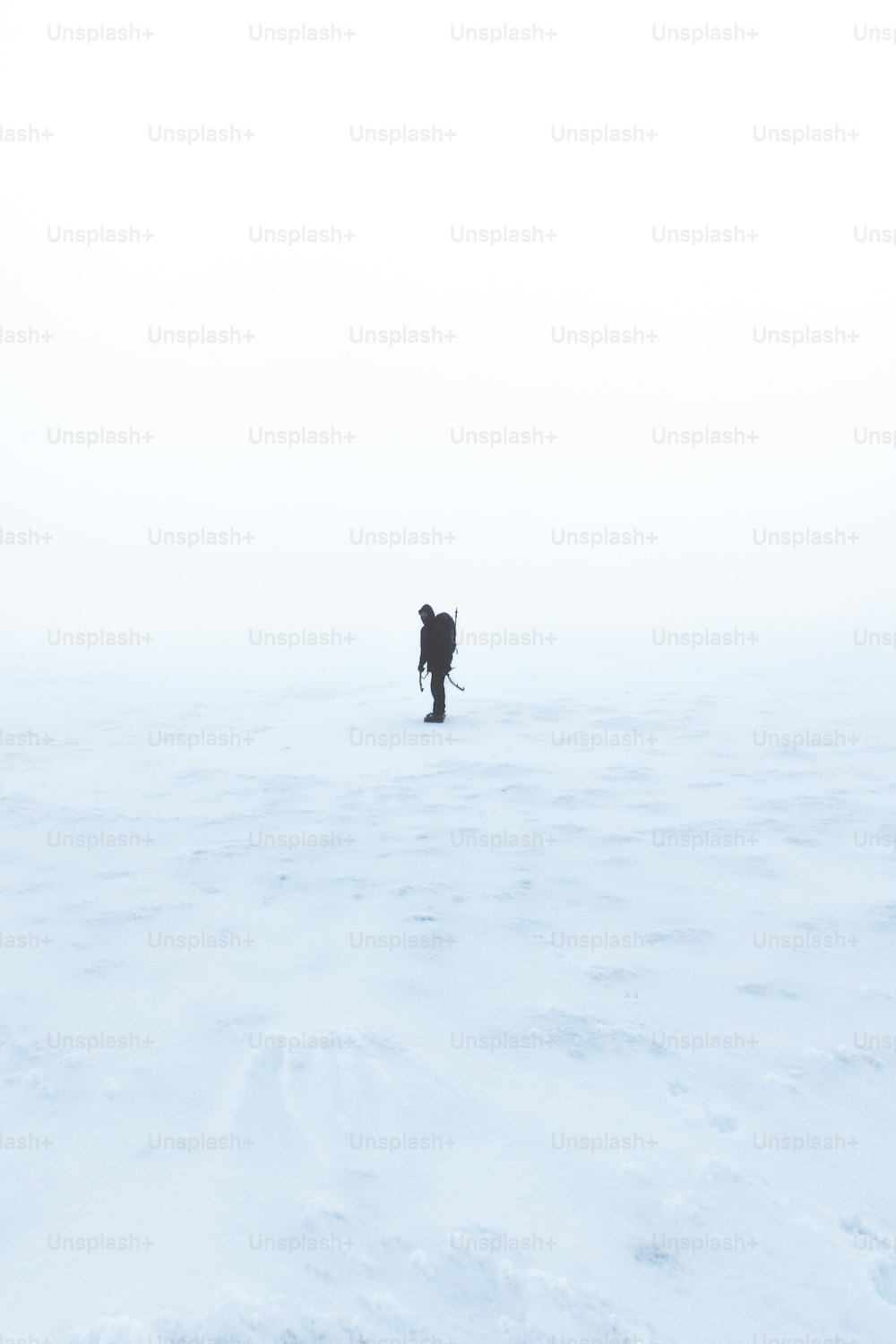 eine Person, die über ein schneebedecktes Feld geht