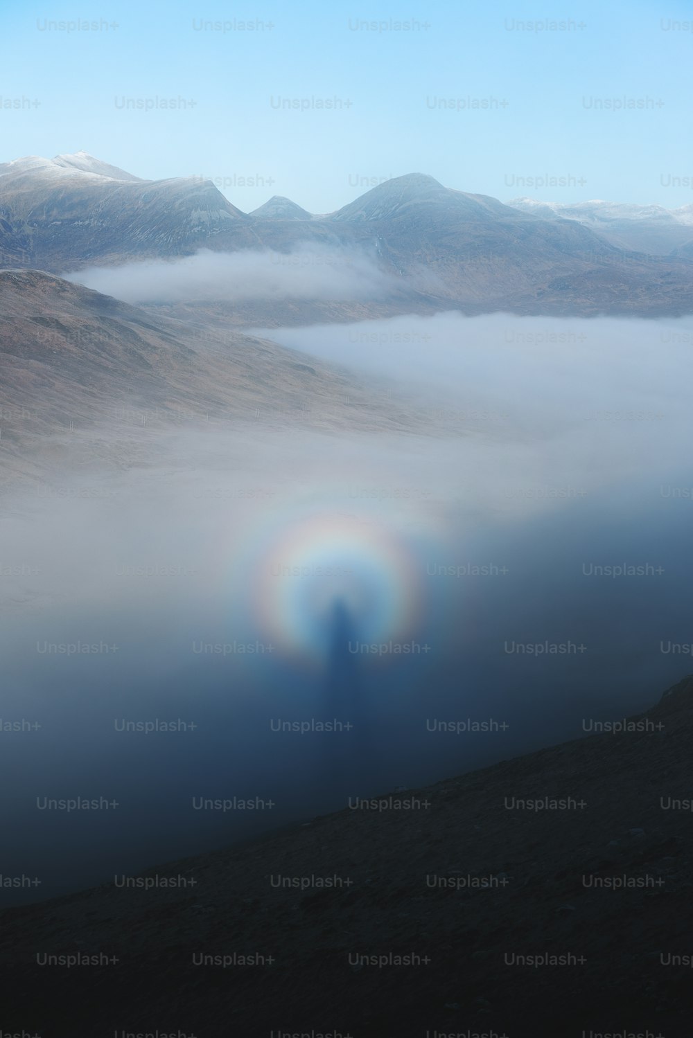 a person standing in the middle of a foggy valley