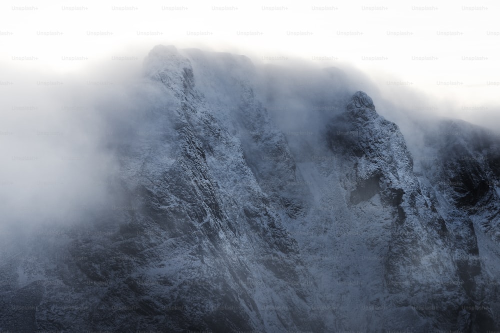 Ein sehr hoher Berg, der mit Schnee und Wolken bedeckt ist