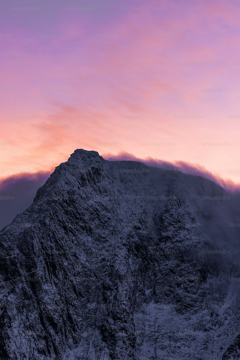 uma montanha muito alta com um céu rosa no fundo