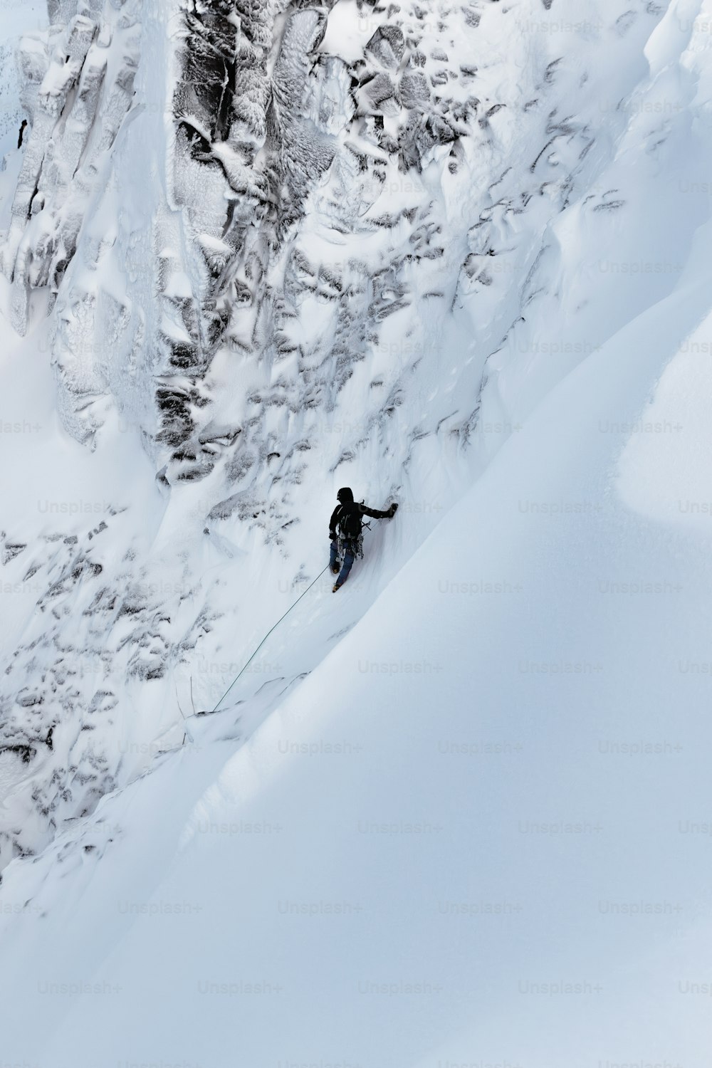 una persona che scia lungo un fianco innevato di una montagna
