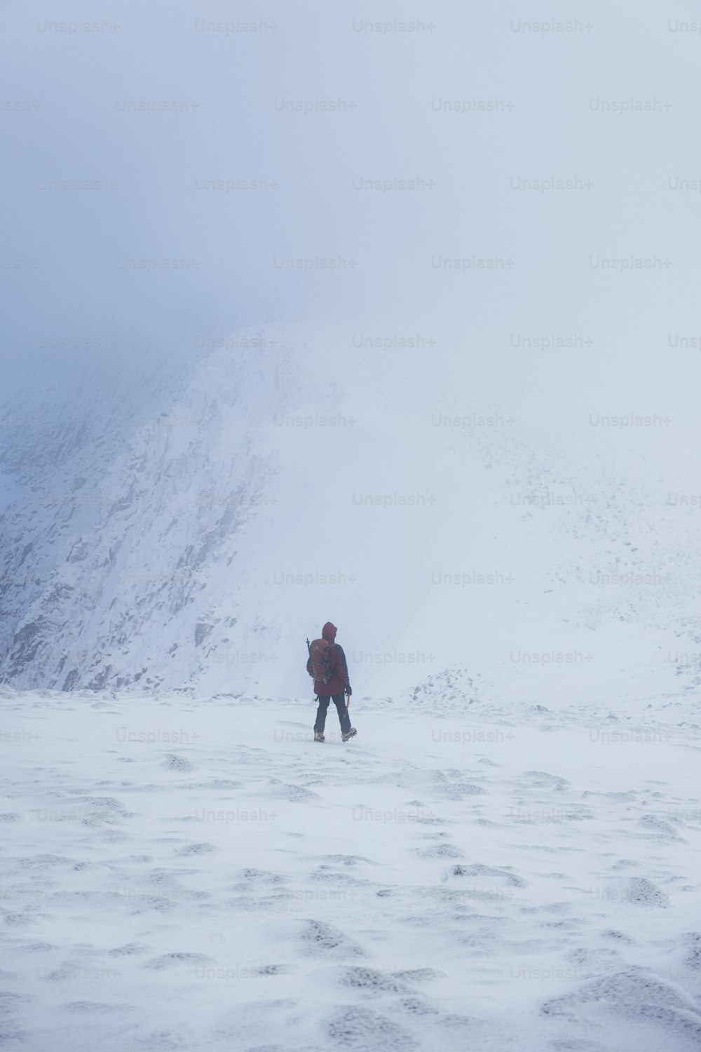 a person standing in the snow with a mountain in the background