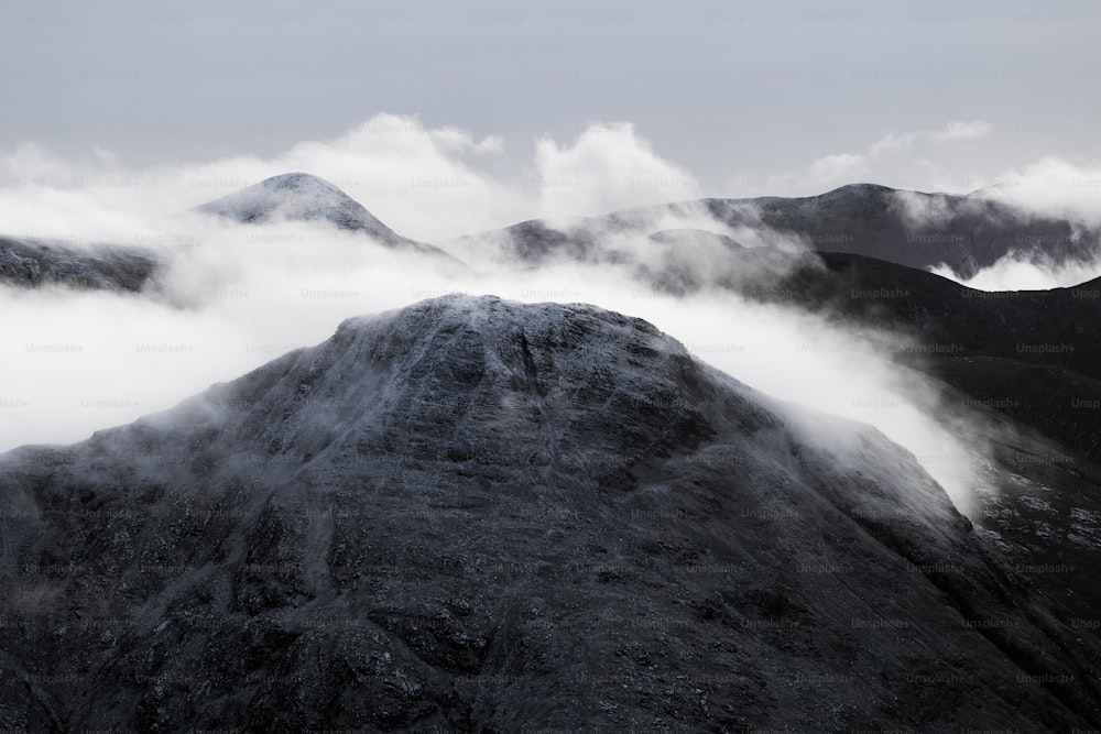 a mountain covered in fog and clouds on a cloudy day