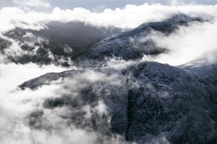 una foto in bianco e nero di montagne e nuvole