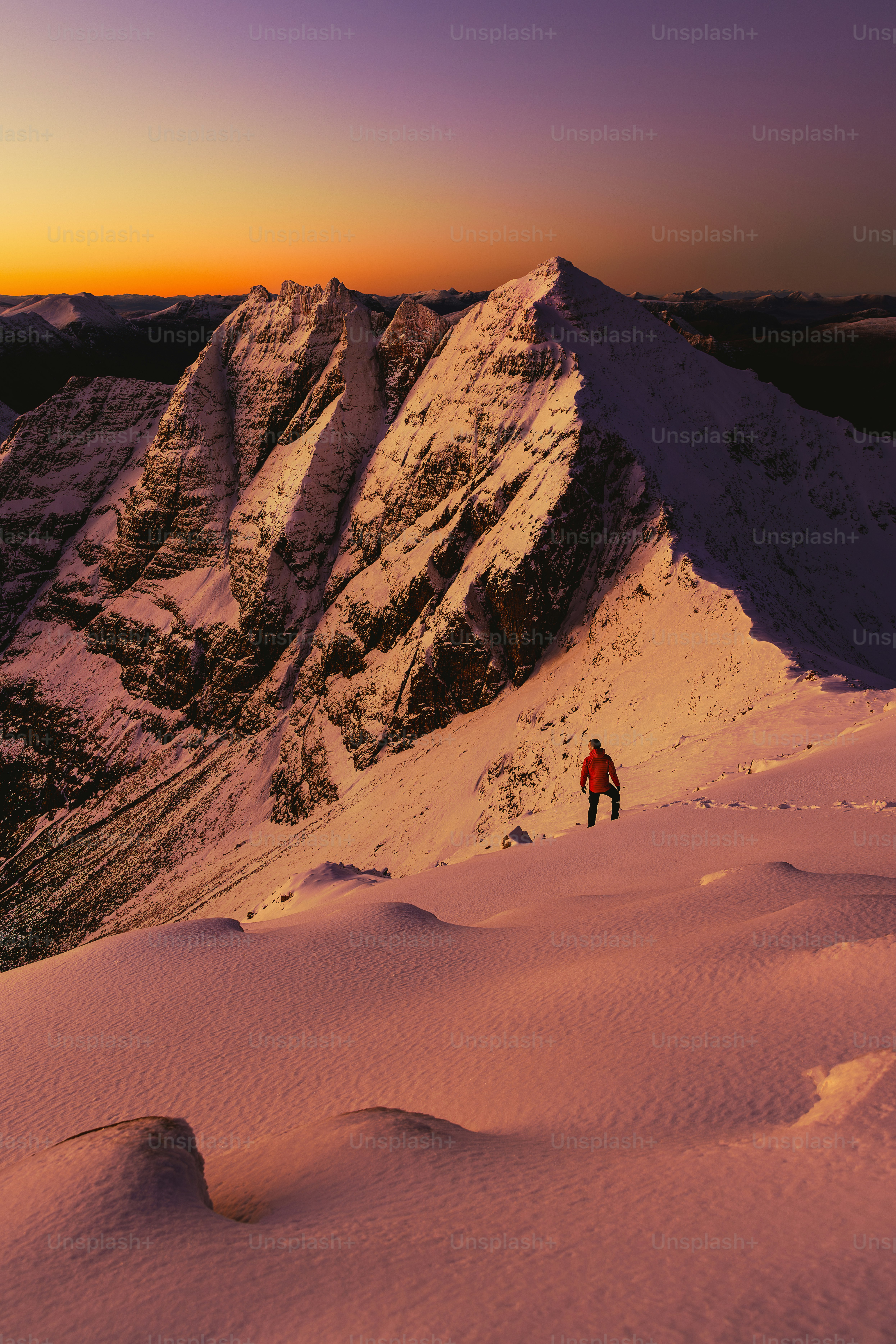 um homem no topo de uma montanha coberta de neve