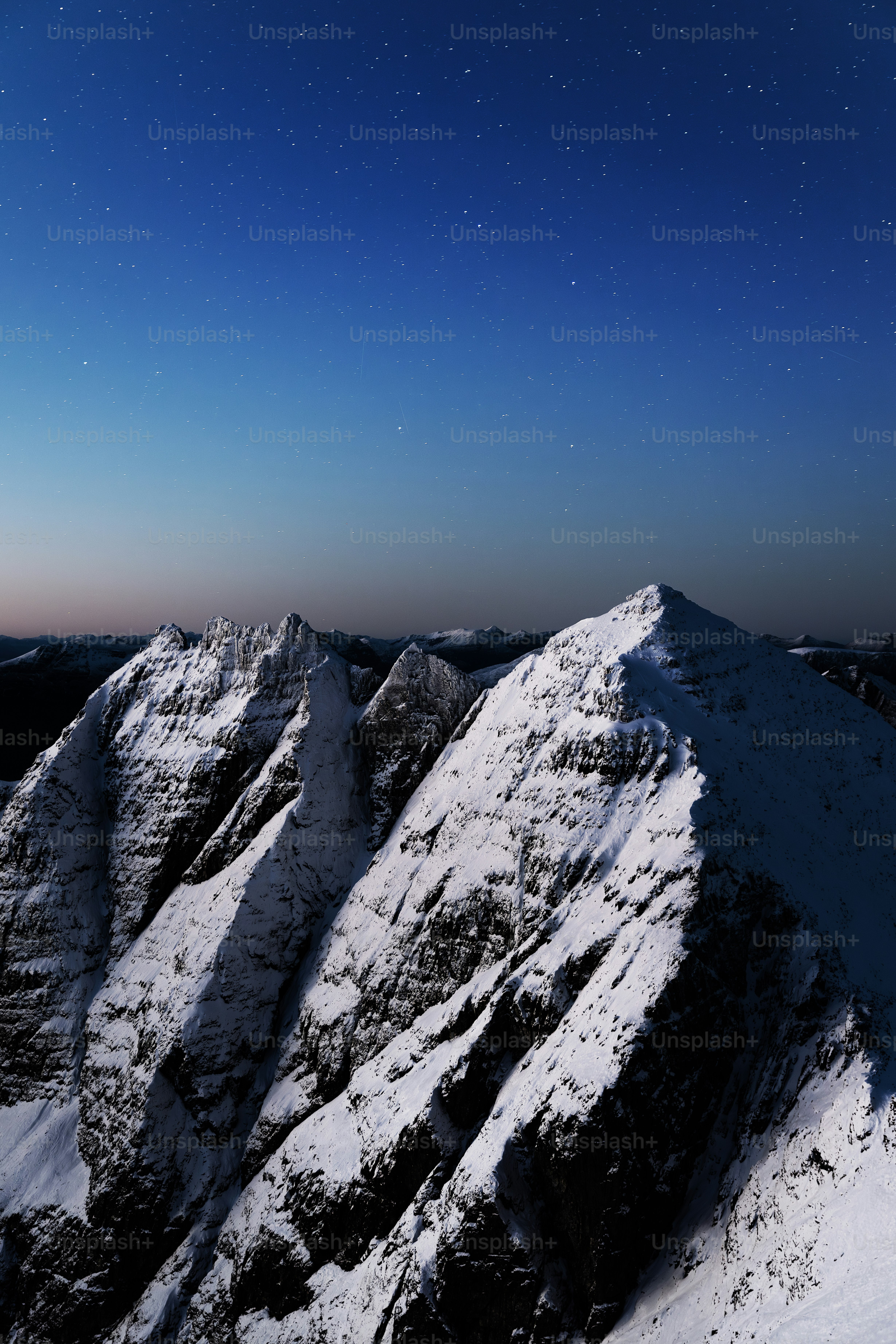 A snow covered mountain under a night sky photo – An teallach Image on ...