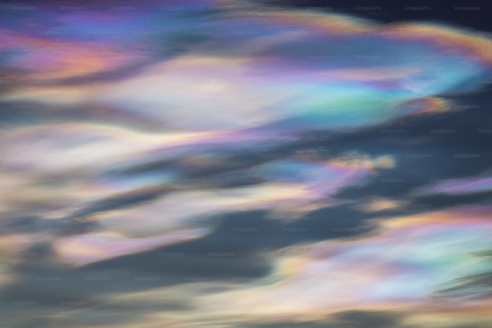 a plane flying through a cloudy blue sky