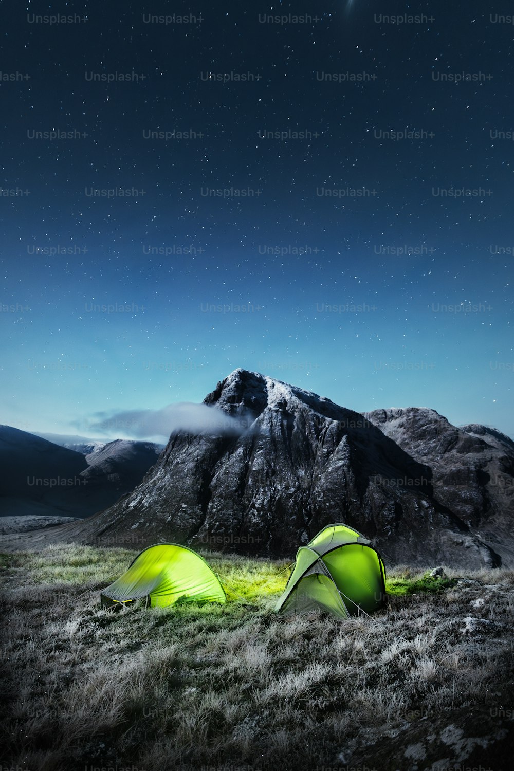 a couple of tents sitting on top of a grass covered field