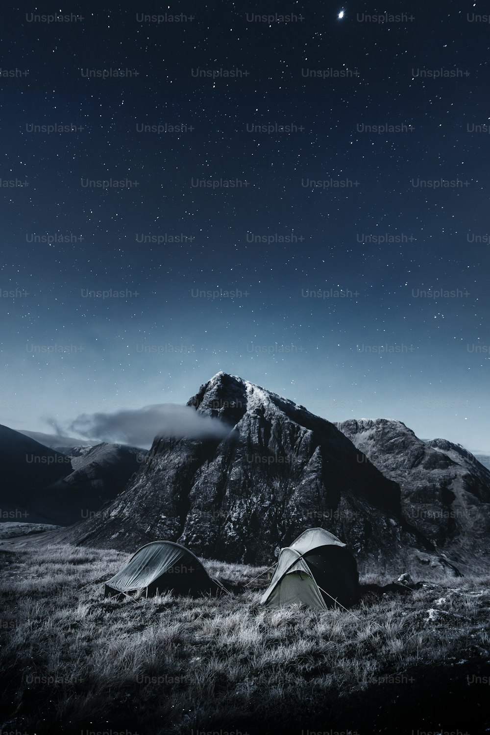 a couple of tents sitting on top of a grass covered field