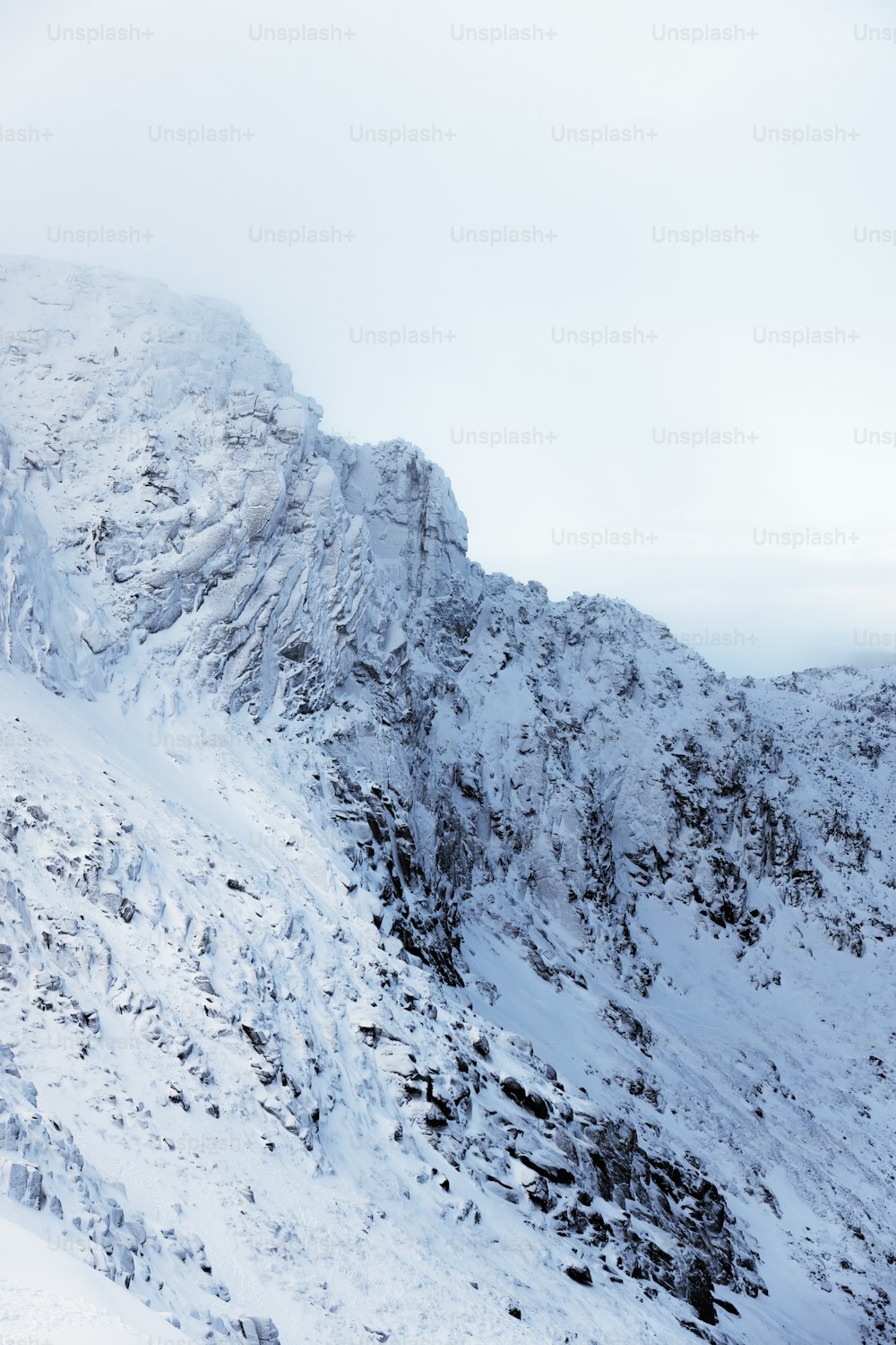 una montaña cubierta de nieve con una persona en esquís