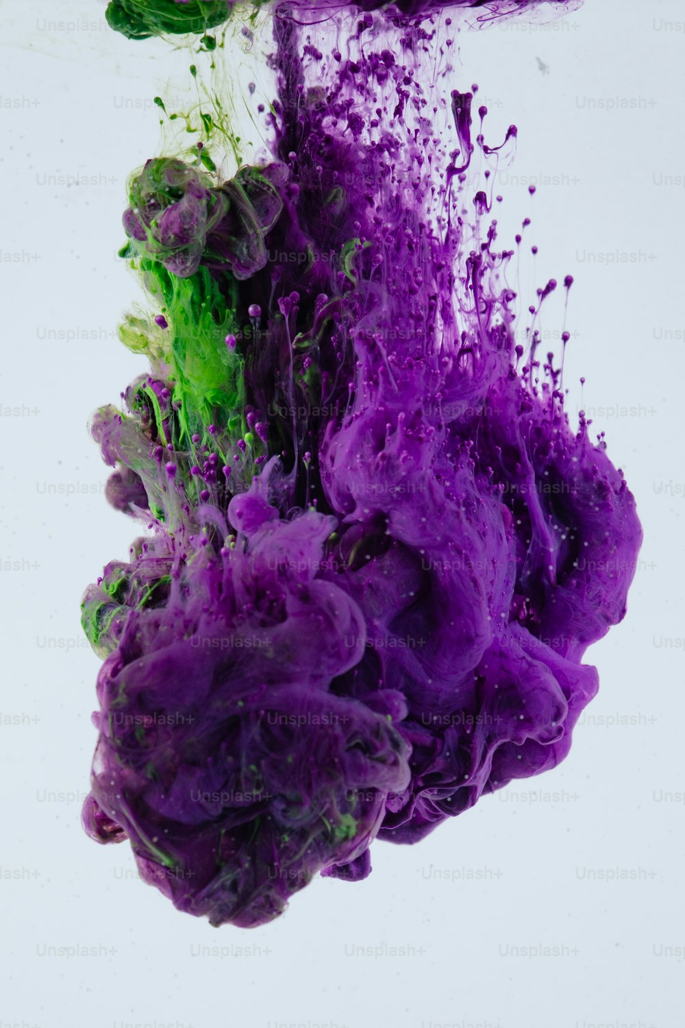 a purple and green substance floating in water
