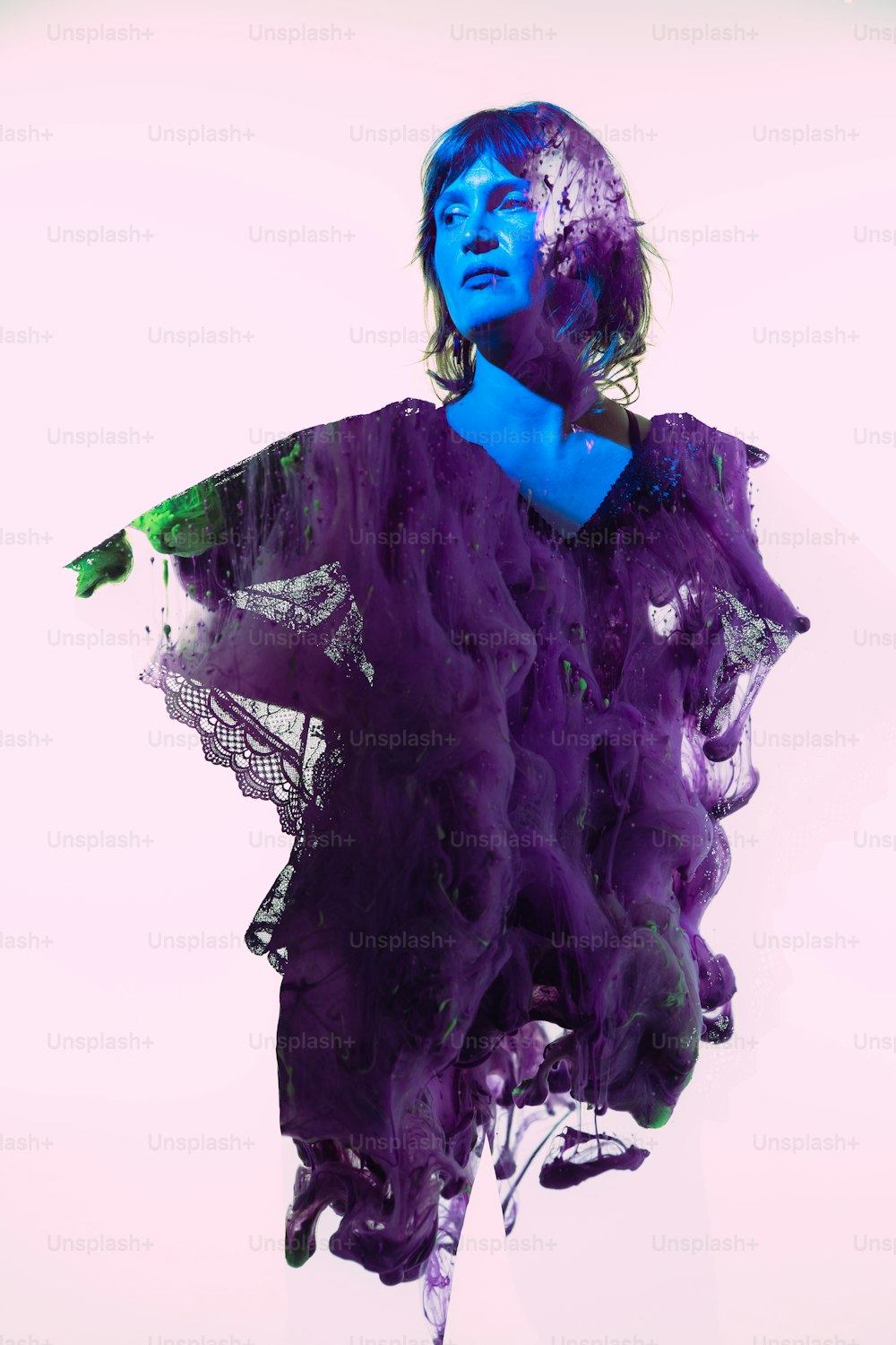 a woman in a purple dress with blue paint on her face