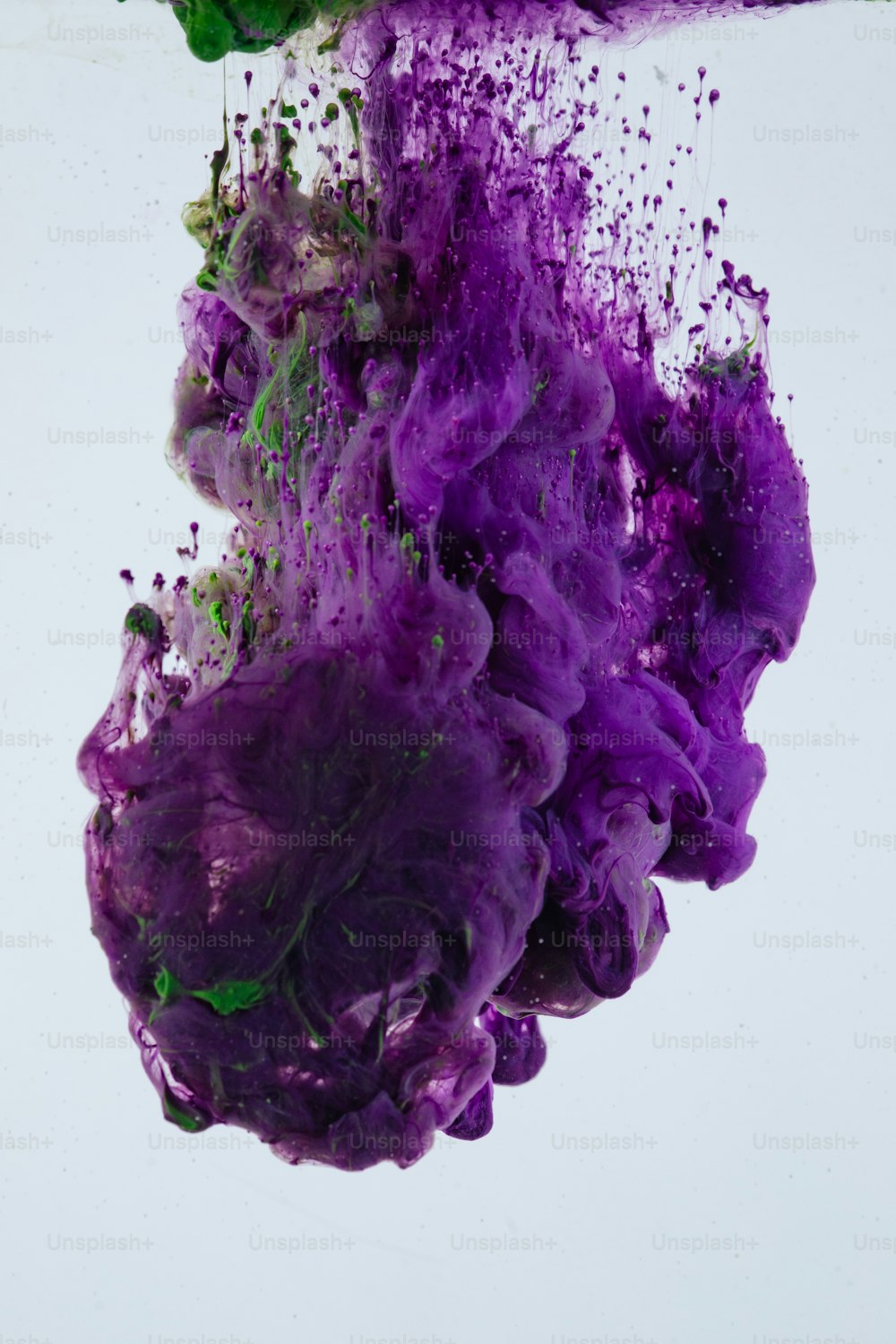 purple and green ink floating in water