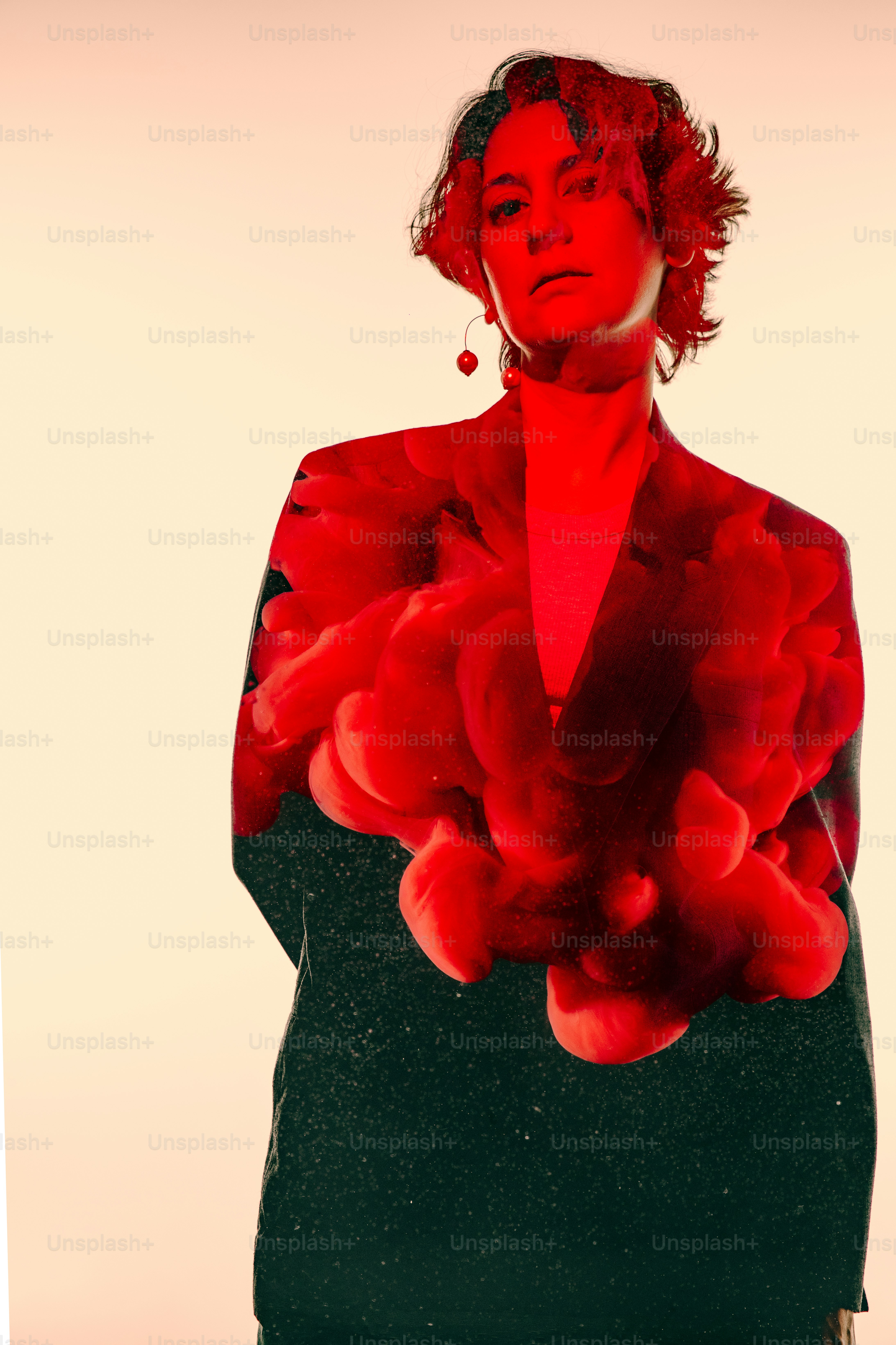 A woman with red hair is standing in front of a white background photo ...