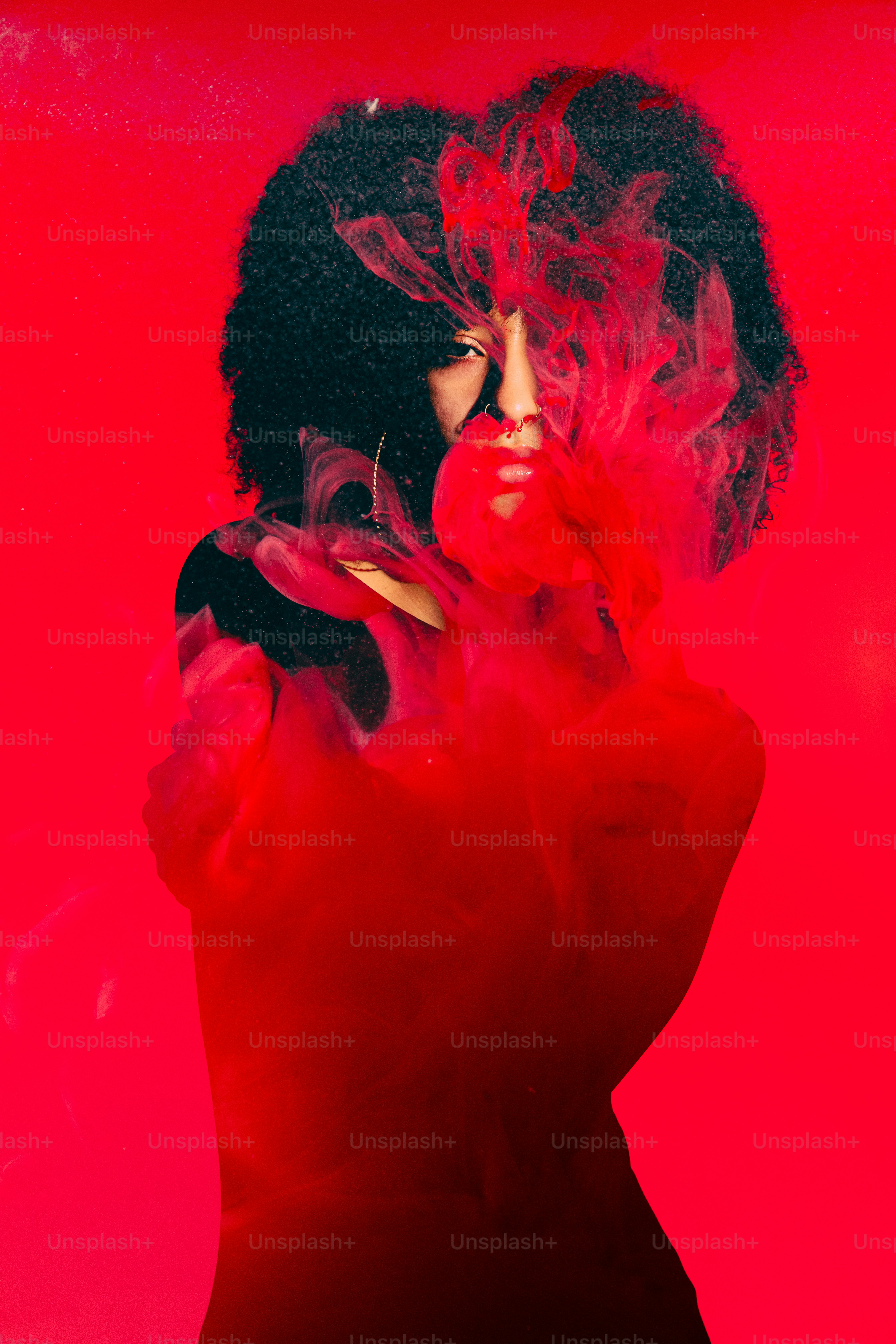 빨간 드레스를 입은 여성이 담배를 피우고 있다