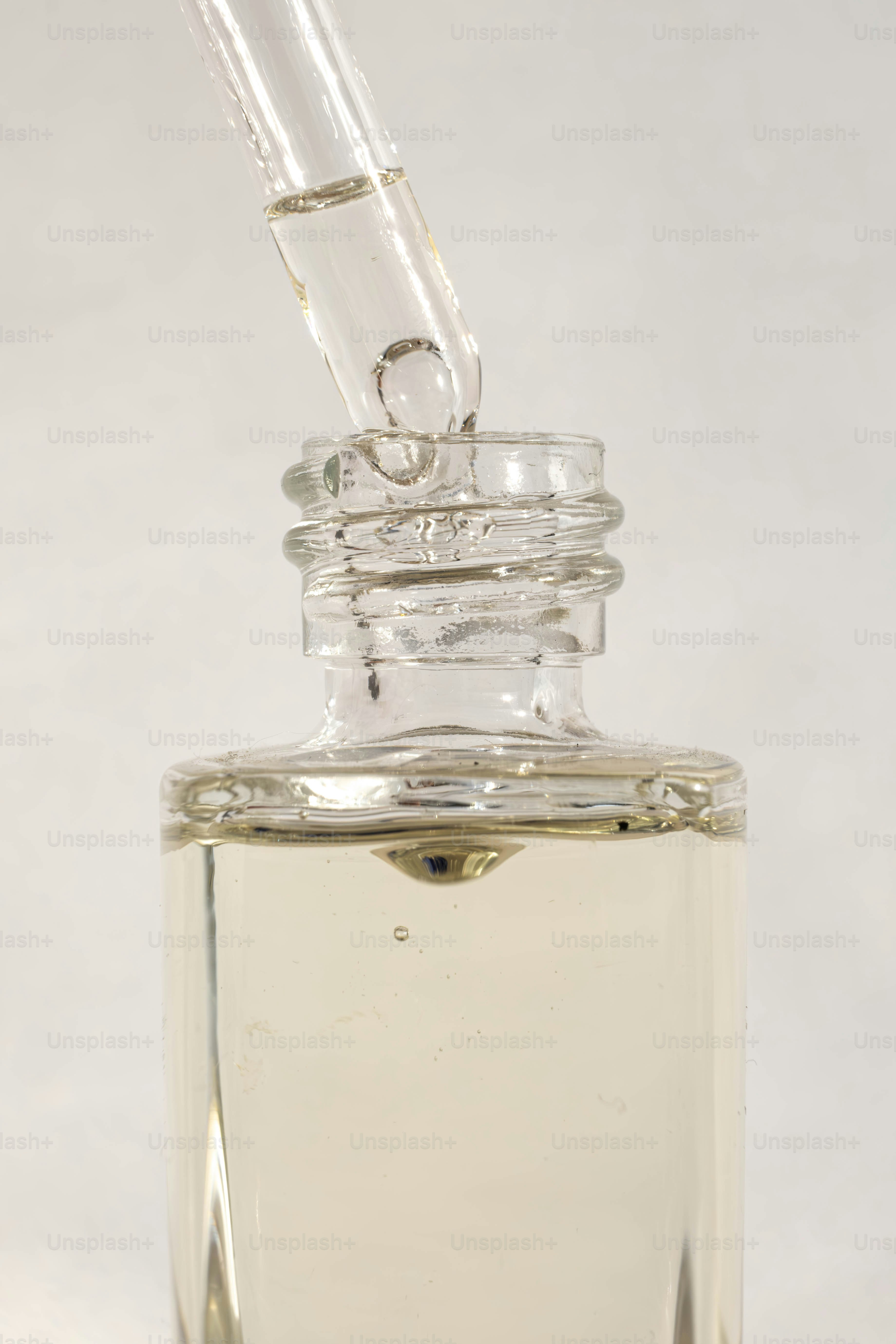 a clear glass bottle with a small pipe sticking out of it