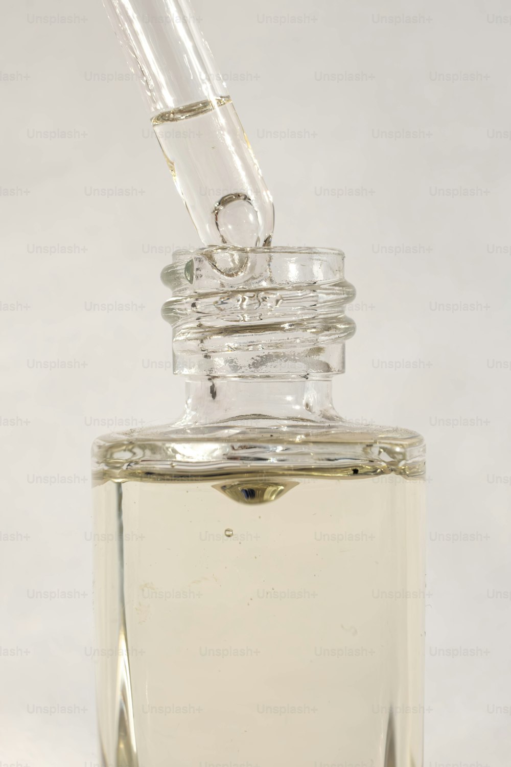 una botella de vidrio transparente con un pequeño tubo que sobresale de ella