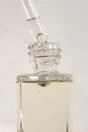a clear glass bottle with a small pipe sticking out of it