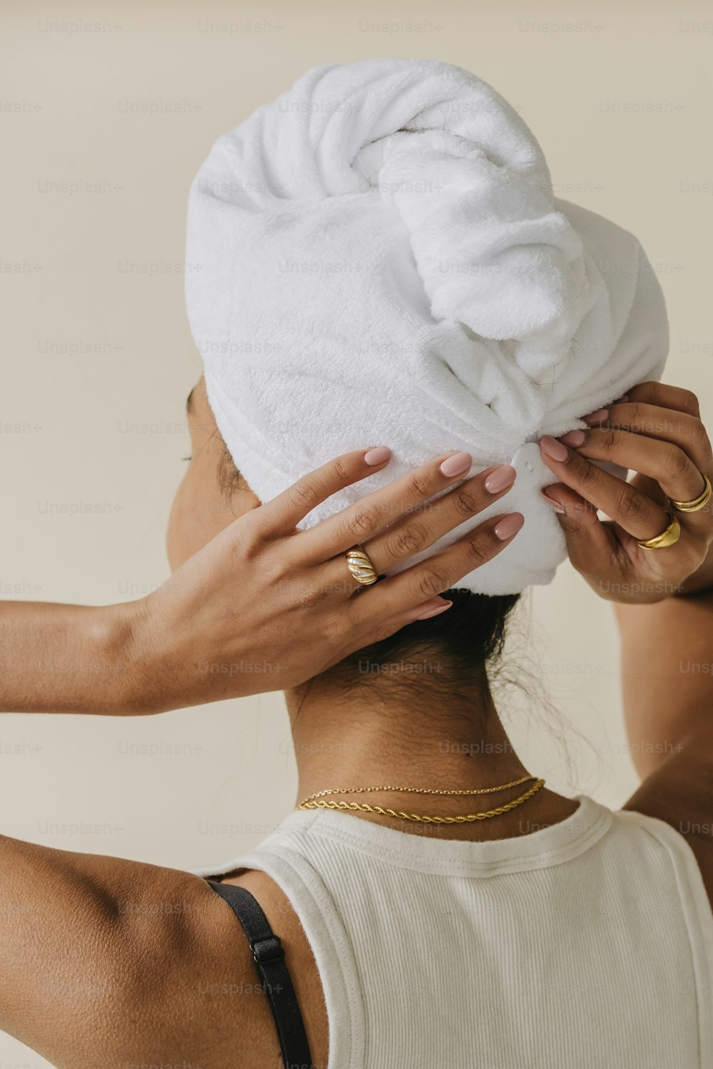 uma mulher colocando uma toalha na cabeça