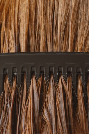 a close up of a comb with brown hair