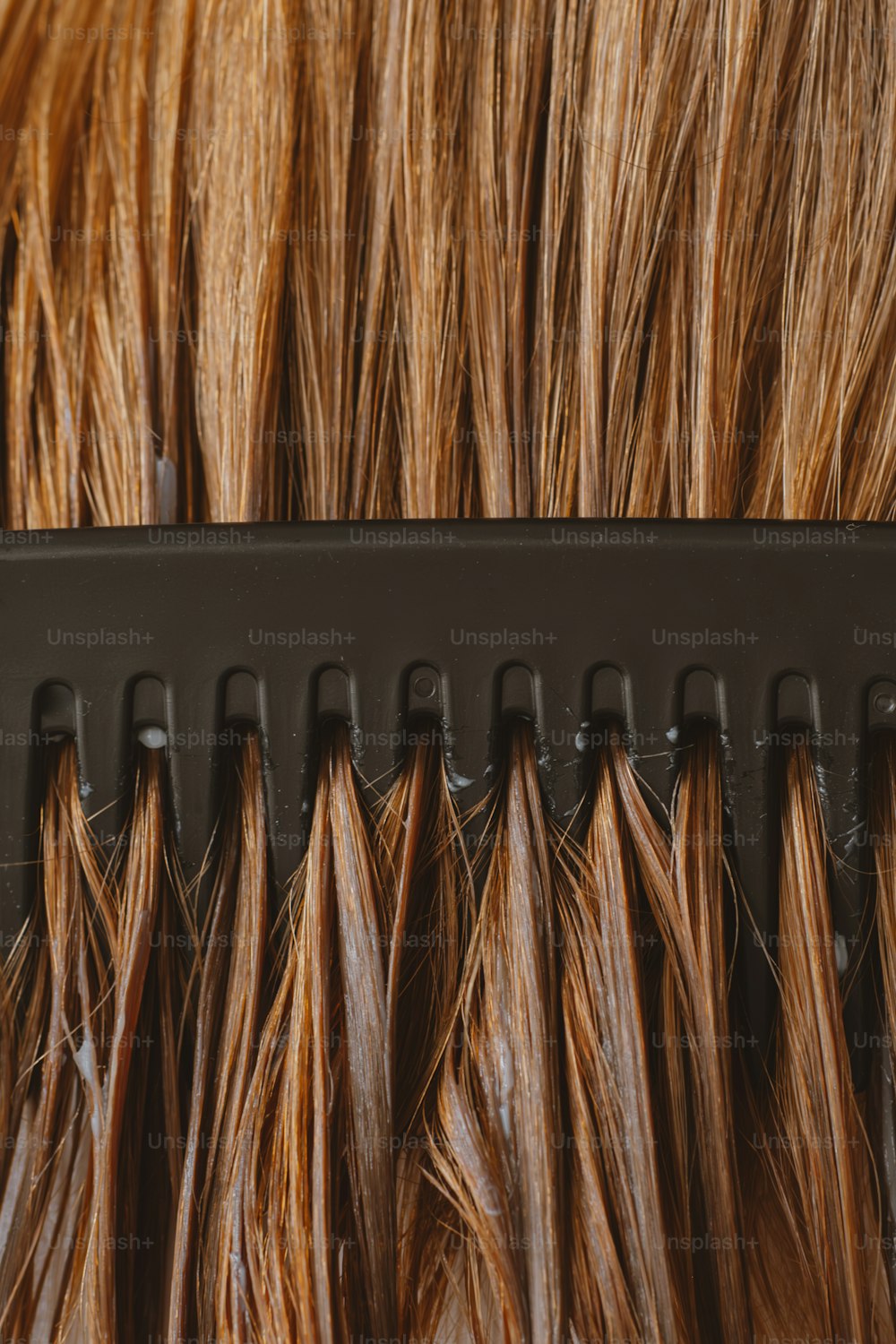 a close up of a comb with brown hair