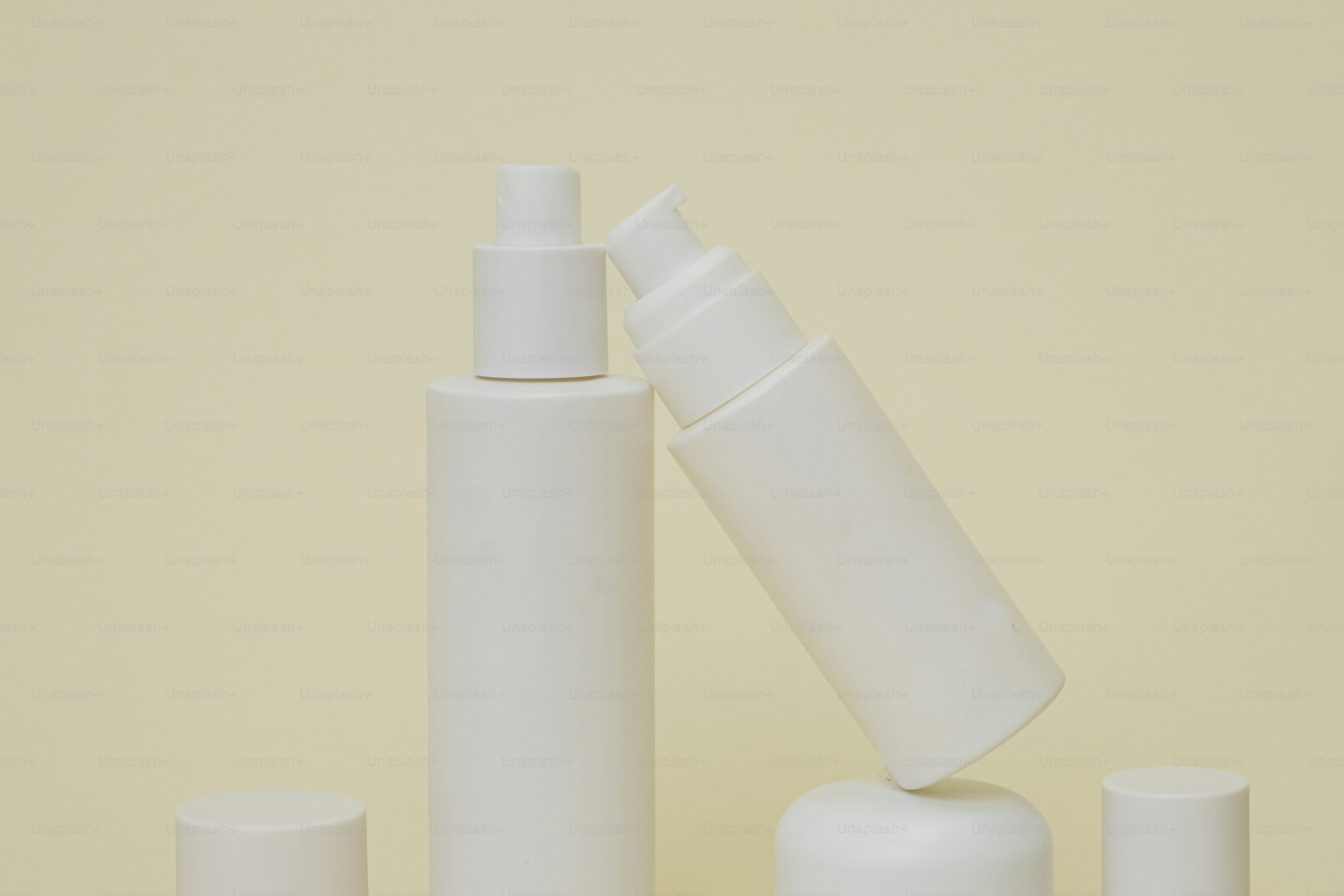 three white bottles and a tube of lotion on a table