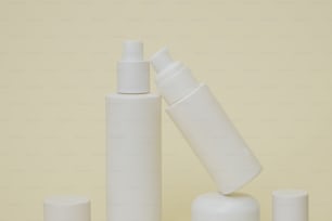 tres frascos blancos y un tubo de loción sobre una mesa