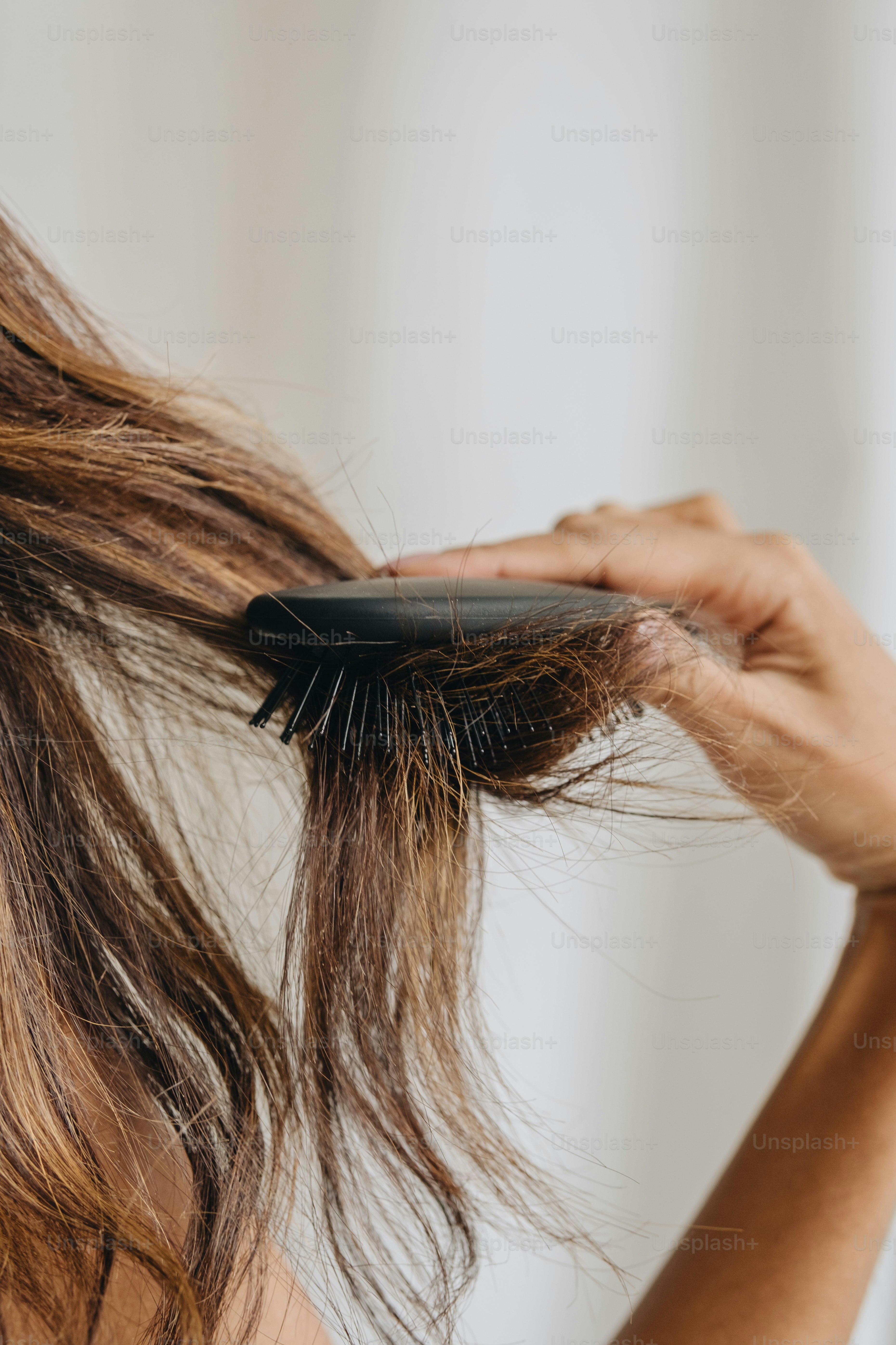 eine Frau, die sich mit einer Bürste die Haare kämmt