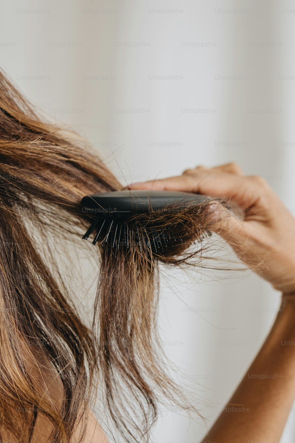 une femme se brossant les cheveux avec une brosse