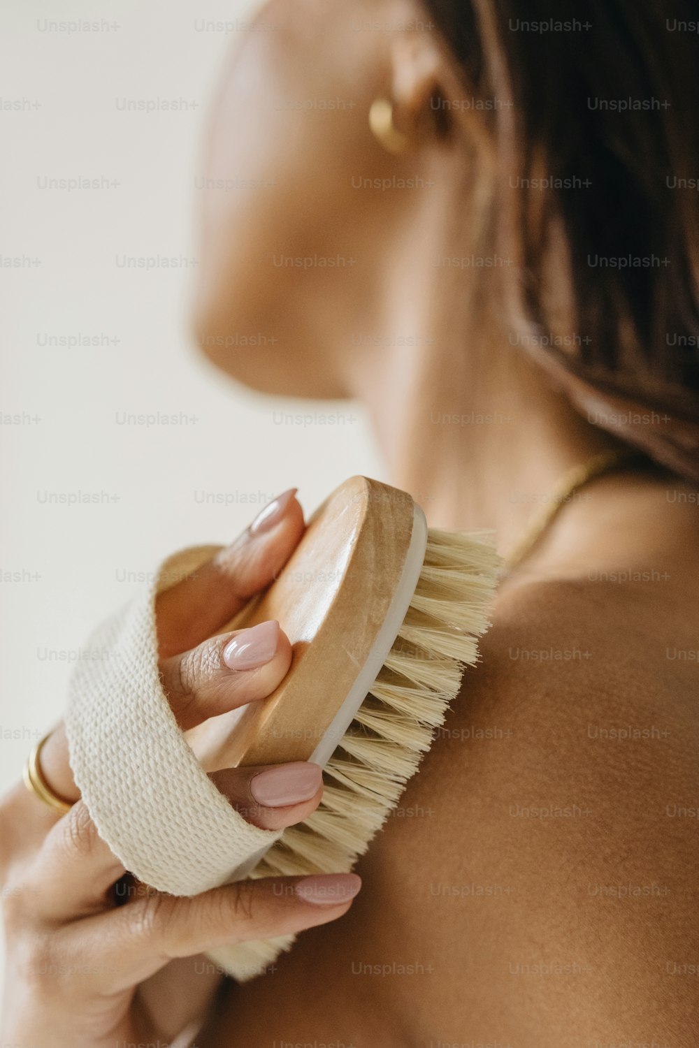 a woman brushes her breast with a brush